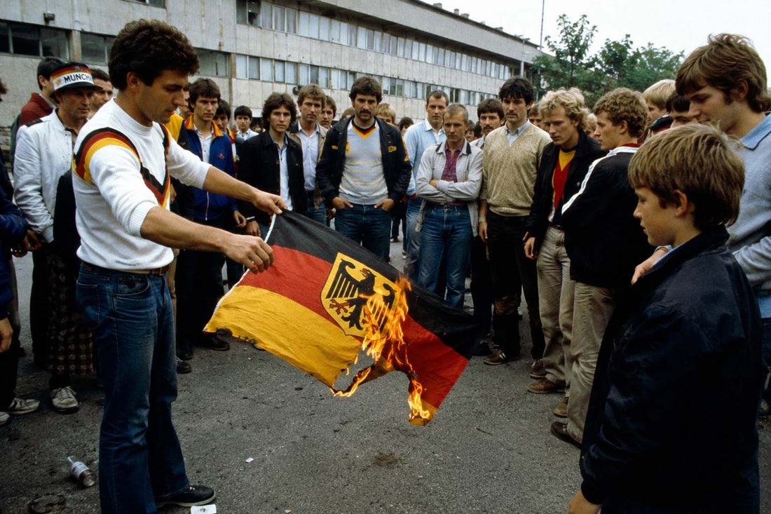 Des supporters allemands brûlent leur drapeau après le match de la Honte de Gijon.